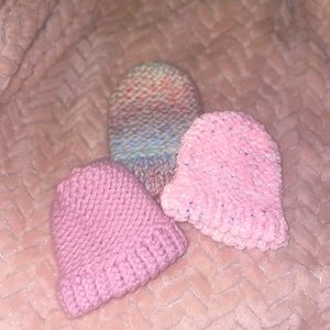 Homemade crochet baby hats for a baby girl, in a set of three.